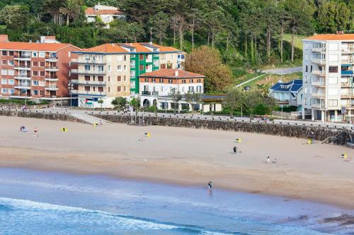 a beach with a group of people on the sand at Hotel Arimune in Bakio