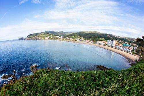 a view of a beach with buildings and the ocean at Hotel Arimune in Bakio