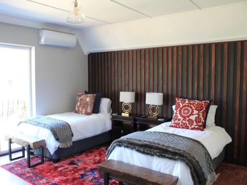 um quarto de hotel com duas camas e uma janela em Wild Tree Lodge em Benoni