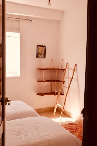 a room with two beds and a shelf in the wall at Olas Experience - Tidehunter in Imsouane