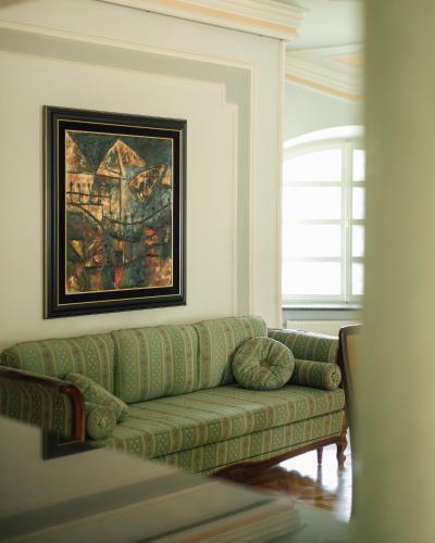 a living room with a green couch and a painting at Elite House in Palić