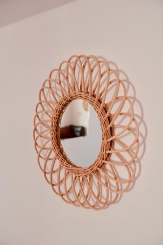 a rattan mirror with a wicker frame on a table at Olas Experience - Tidehunter in Imsouane