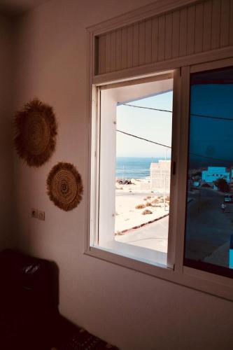 a window in a room with a view of the beach at Olas Experience - Tidehunter in Imsouane