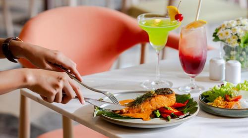 a person eating food on a table with a plate of food at Novotel Rayong Star Convention Centre in Rayong