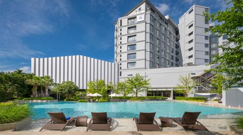 ein Hotel mit einem Pool und Liegestühlen in der Unterkunft Novotel Rayong Star Convention Centre in Rayong