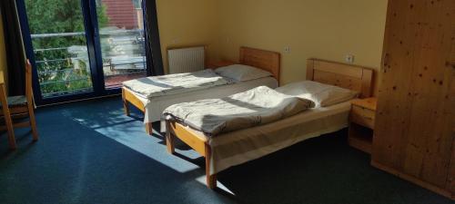 two twin beds in a room with a window at Ubytovna Zimní stadion in Litoměřice