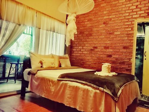 um quarto com uma cama e uma parede de tijolos em แม่อุ๊ยโฮมสเตย์&mae uai homestay em Ban Pok Nai