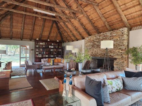 a living room with a couch and a fireplace at Karongwe River Lodge in Karongwe Game Reserve