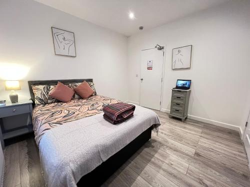 een slaapkamer met een bed met een koffer erop bij Dunamis Staycation 5 in Croydon