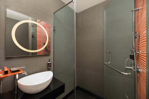 La salle de bains est pourvue d'un lavabo et d'une douche en verre. dans l'établissement Ginger East Delhi, à New Delhi