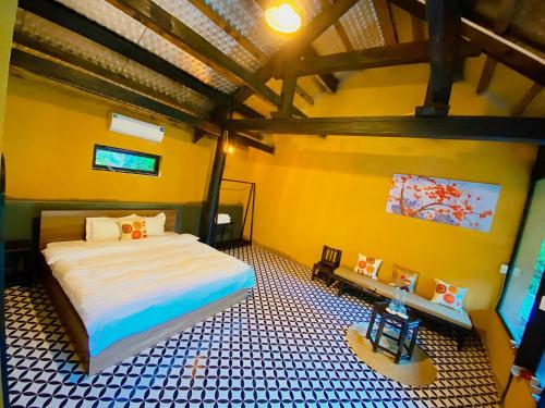 ein Schlafzimmer mit einem Bett in einem Zimmer mit gelben Wänden in der Unterkunft Moc Chau Retreat in Mộc Châu