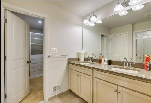 a bathroom with a sink and a large mirror at Stunning four-bedroom town home in Millersville