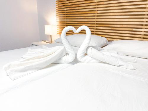 two swans making a heart shape on a bed at Casa junto al Mar in El Ejido
