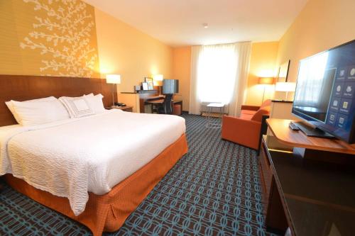 a hotel room with a bed and a flat screen tv at Fairfield Inn & Suites by Marriott Chincoteague Island Waterfront in Chincoteague