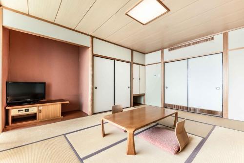a living room with a table and a tv at Spa and Resort Hotel Solage Oita Hiji Beppuwan in Beppu