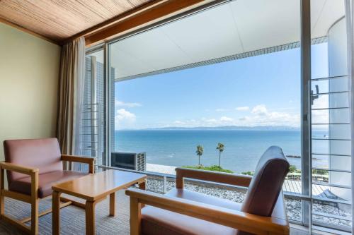 a living room with a view of the ocean at Spa and Resort Hotel Solage Oita Hiji Beppuwan in Beppu