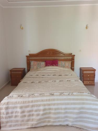 a bedroom with a large bed with two night stands at Appartement in Oujda