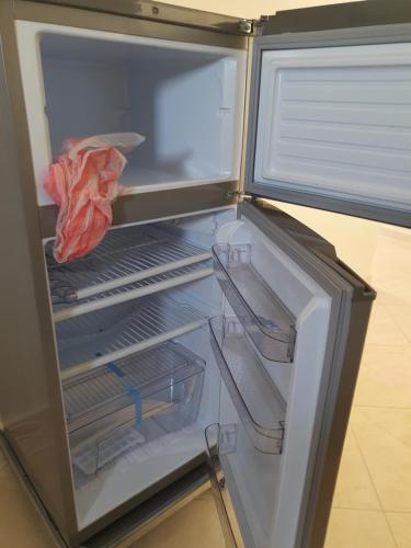 an empty refrigerator with its door open with its door open at Appartement in Oujda