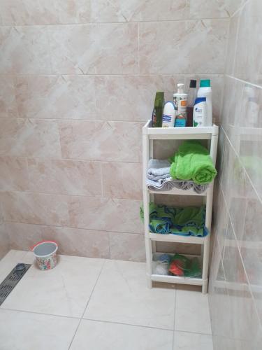 a bathroom shelf with towels and other items on it at Appartement in Oujda