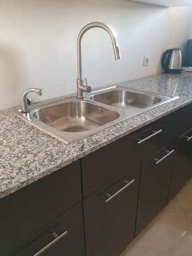 a kitchen counter with a stainless steel sink at Appartement in Oujda