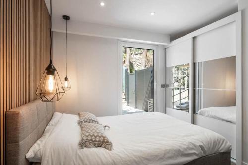 een slaapkamer met een bed en een groot raam bij Les Terrasses de Monaco in Roquebrune-Cap-Martin