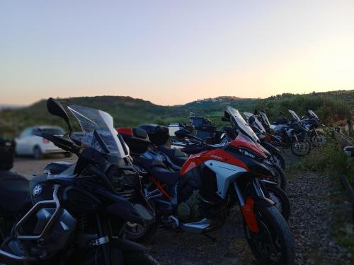 a row of motorcycles parked on the side of a road at La Corte degli Ulivi - Albergo Rurale in Tresnuraghes