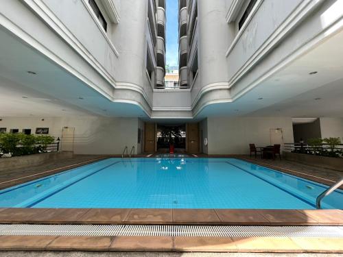 a large swimming pool in a building with a ceiling at Baan Sawasdee Residence in Bangkok