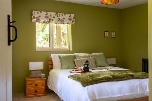 a green bedroom with a bed and a window at The Lookout in Fritham