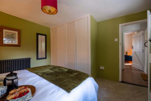 a bedroom with a large bed with green walls at The Lookout in Fritham