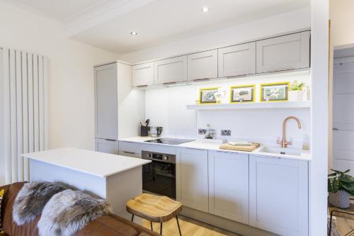 a kitchen with white cabinets and a sink at Hidden Gem – Luxe Clifton Apartment with Views in Bristol
