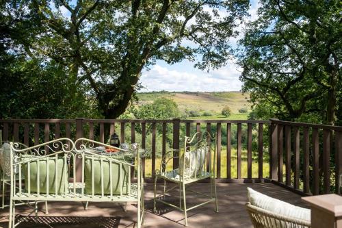 a patio with two chairs and a table and a fence at The Lookout in Fritham