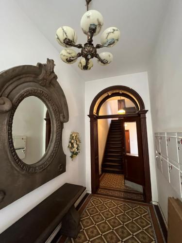 un couloir avec un miroir et un escalier avec un lustre dans l'établissement Retro Appartement im Herzen von Köln Deutz, à Cologne