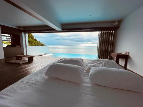 a bedroom with a bed with a view of the ocean at Secret Pool villa Seji in Bise