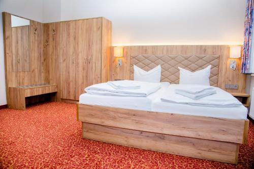 フリードリッヒローダにあるWaldhotel Friedrichrodaのベッドルーム(白いシーツを使用した大型ベッド1台付)
