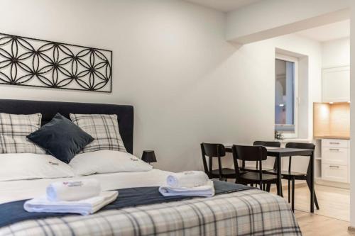 1 dormitorio con 1 cama, mesa y sillas en Apartamenty Kwiatowa w Szczawnicy BEZPŁATNY PARKING en Szczawnica