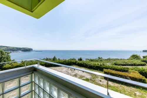 a balcony with a view of the ocean at Spa and Resort Hotel Solage Oita Hiji Beppuwan in Beppu
