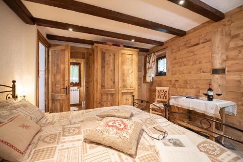 sypialnia z łóżkiem w pokoju z drewnianymi ścianami w obiekcie Chalet La Garde w mieście Valtournenche
