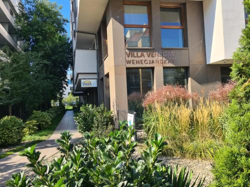 a building with a garden in front of it at VENICE VILLA Apartment, self check-in 24h, free parking in Poznań
