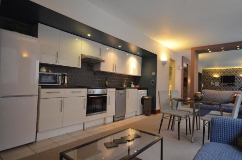 a kitchen with white cabinets and a table and chairs at Flat In Camden Town in London