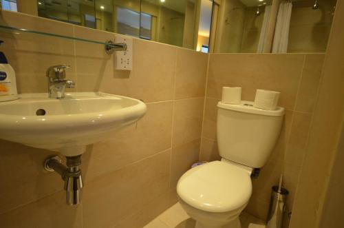 a bathroom with a toilet and a sink at Flat In Camden Town in London