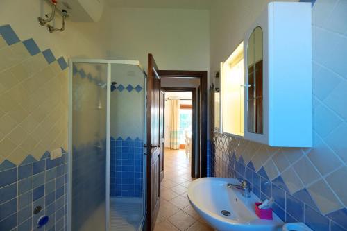 Fantastic Residenza Badus 1 BedRoomApart sleeps 4 plus possible child bed No0815 في باديسي: حمام من البلاط الأزرق مع حوض ودش
