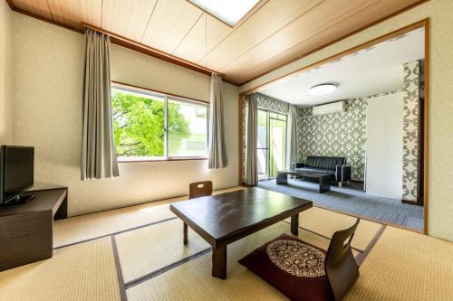 a living room with a table and a couch at Spa and Resort Hotel Solage Oita Hiji Beppuwan in Beppu