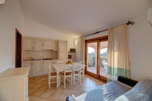 a kitchen with a table and a dining room with a window at The Fantastic Residenza Badus two bedroom sleeps six plus child num0818 in Badesi