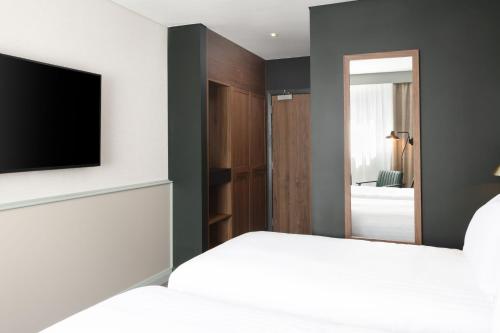 a bedroom with a bed and a flat screen tv at Four Points by Sheraton Edinburgh in Edinburgh