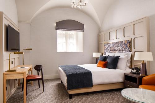 a hotel room with a large bed and a desk at The Municipal Hotel Liverpool - MGallery in Liverpool