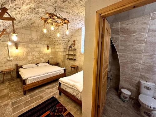 a room with two beds and a toilet in it at Taşkıran Boutique Hotel in Urfa