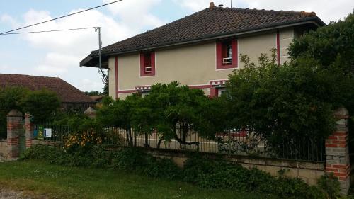 une maison avec des fenêtres rouges et une clôture dans l'établissement A la Bonne Franquette, à Droyes