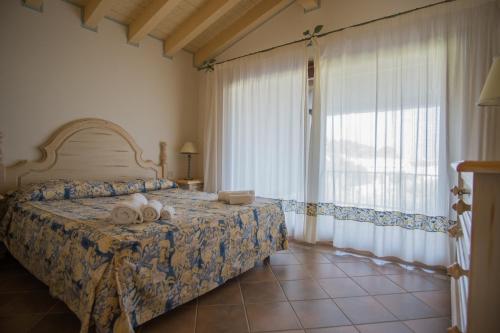 een slaapkamer met een bed met handdoeken erop bij Beautiful Il Giardino degli Oleandri one bedroom sleeps two num0852 in Liscia di Vacca