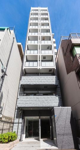 a tall building with a large white building at Apartment Hotel 11 Kuromon 2 in Osaka