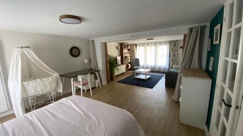 een slaapkamer met een bed en een woonkamer bij 30mn de Paris st lazare en train, studio 42 m2 in Verneuil-sur-Seine